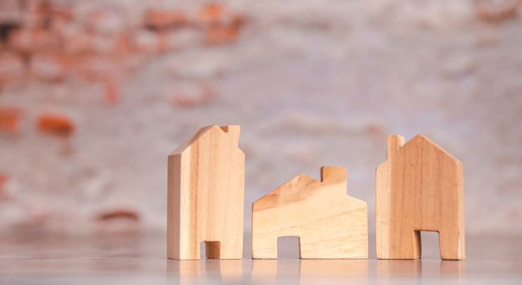 Photo of three houses made of wooden blocks